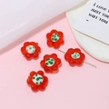 Dettaglio di perline a fiore in vetro rosso con accenti bianchi e verdi per gioielli fai da te - Rosso