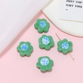 Macro shot of green glass flower beads with blue spotted centers for DIY jewelry making - Green