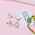 Makroaufnahme quadratischer Roboter-Glasperlen mit Smileys für DIY-Schmuckherstellung - Roboter-Form / Weiß
