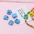 Makroaufnahme bunter handgefertigter Glasperlen mit Robotergesicht für DIY-Schmuck - Roboter-Form / Blau