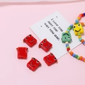 Nahaufnahme bunter handgefertigter quadratischer Glasperlen mit Smileys für DIY-Schmuck - Roboter-Form / Rot