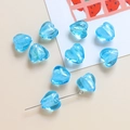 Makroansicht einer blauen Herz-Glasperle mit Goldglitter für DIY-Schmuckherstellung - Seeblau