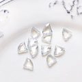 Macro shot of faceted triangle glass beads on a ceramic plate for DIY jewelry making - Blue Gray