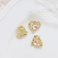 Close-up of lava textured heart charms with aurora crystals for DIY jewelry making - Gold Melting Heart