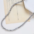 Vue détaillée de perles en verre de cristal facetté gris métallisé sur fond blanc - Style Facetté Fin / Argent Profond Métallique Iridescent