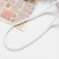 Macro shot of faceted milky white glass beads on vintage newspaper for DIY jewelry crafting - 100个装/条 / Creamy White