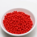 Detailed view of 4mm bright red seed beads in a white bowl for DIY jewelry making - 4mm / Red