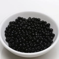 Detailed view of 4mm glossy black ceramic beads piled in a white porcelain bowl for DIY jewelry - 4mm / Black