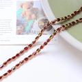Close-up of vintage oval ruby beads with gold metal frames for DIY jewelry design - Burgundy