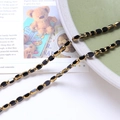 Macro view of vintage style black oval beads with gold edges for DIY jewelry making - Black