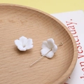 Macro-opname van twee witte harsbloemkralen voor DIY-sieraden op een houten dienblad - 14#