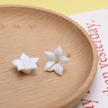 Macro-opname van witte keramische bloemen met gouden metalen pin voor DIY-sieraden maken - 10#