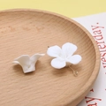 Macro-opname van witte hars bloembedeltjes en metalen pinnen voor DIY sieraden - 6#