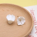 Close-up of white resin flower charms with metal pins for DIY handmade jewelry crafts - Style 1