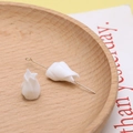 Detailopname van witte tulpvormige keramische kralen met gouden pinnen op hout - 13#