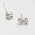 Detailed silver bow stud earrings with center zircon stone and secure needle back - Bow / White Gold