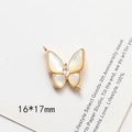 Dettaglio ciondolo a farfalla placcato oro 16*17mm con intarsio in madreperla e strass - Farfalla in Zirconia Doppio Occhiello