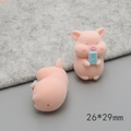 Detailed view of pink flocked 3D pig charms in sitting and lying poses, size 26x29mm - Photography Pig (D2082)