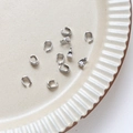 Gros plan d'attaches de pendentif en métal argenté pour bijoux sur une assiette crème - Bélières Argent Blanc