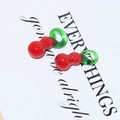 Close-up of vibrant red and green fruit-shaped handmade glass beads for DIY jewelry - Gourd
