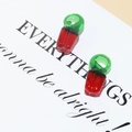 Macro shot of realistic red chili-shaped glass beads for DIY jewelry making and crafts - Chili