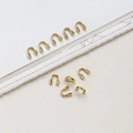Vista macro de protectores de hilo en forma de U bañados en oro 14k para collares y pulseras - Protector de Hilo en U Tono Oro 14K / Dorado