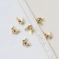 Close-up of 14K gold-plated C-shaped jewelry clamshell bead tips for DIY necklaces - 18K Gold Tone Double-End Calotte
