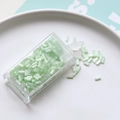 Detail of 2mm mint green glass bugle beads for DIY crafts in a clear storage box - Green