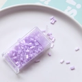 Macro view of 2mm purple bugle beads in a storage box for DIY embroidery crafts - Purple