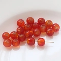 Macro shot of orange translucent glass beads with gold foil for DIY jewelry making - Red Orange