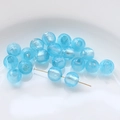 Macro shot of light blue translucent glass beads with gold pins for DIY jewelry making - Sky Blue