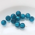 Detailed macro of translucent blue glass beads with silver foil for DIY jewelry making - Lake Green