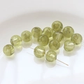 Macro detail of olive green glass beads with gold sand texture for DIY jewelry making - Earth Color
