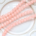 Macro view of light pink crackle glass round beads for DIY jewelry making on porcelain - 1 Strand (Approx. 100-110 Beads) / Orange