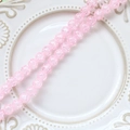 Close-up of pink crackle glass round beads on a white ceramic plate for DIY jewelry - 1 Strand (Approx. 100-110 Beads) / 4# Pink