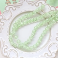 Macro detail of mint green crackle glass beads on a decorative white ceramic tray - 1 Strand (Approx. 100-110 Beads) / Green