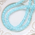 Macro detail of light blue cracked glass beads with ice textures on white ceramic plate - 1 Strand (Approx. 100-110 Beads) / 6# Cyan