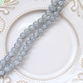 Macro shot of 6-8mm grey-blue crackle glass beads on white vintage porcelain plate - 1 Strand (Approx. 100-110 Beads) / Starry Grey