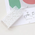 Macro shot of 3mm white macaron glass seed beads in a transparent storage box - Pearl White