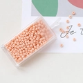 Macro detail of 3mm macaron pink glass seed beads in a clear storage box for DIY jewelry - Lotus root pink