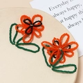 Handmade woven seed bead flower pendants in orange and green for DIY jewelry design - Orange