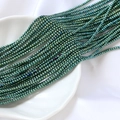 Gros plan de perles de rocaille en verre vert iridescent de 2mm pour bijoux DIY - Style Vert Iridescent