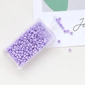 Detail of 3mm light purple macaron glass seed beads in a clear plastic box for DIY jewelry - Purple