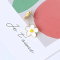 Macro shot of a daisy-shaped flower stud earring with white enamel petals on a gold base - Small White Flower