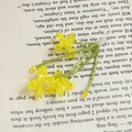 Dettaglio macro di un ciondolo a fiore di perline gialle su una pagina di un libro - 3# Fiore di Cristallo Giallo (Prezzo Unitario)