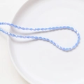 Lavender purple faceted crystal glass rice beads in a ceramic bowl for DIY jewelry - Blue