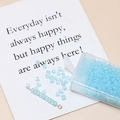 Detail of 3mm light blue translucent frosted glass seed beads in a clear box and on a card - Blue