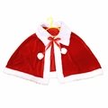 Rode fluwelen kerstcape met witte imitatiebontrand en pompons op een kledinghanger - Volwassene