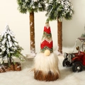 Detalle de adorno de gnomo navideño con gorro de punto y base de madera sobre fondo nevado - Estilo D