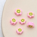 Vue détaillée de perles fleurs en pâte polymère rose avec sourires pour bijoux DIY - Lot de 10 / Rose Clair